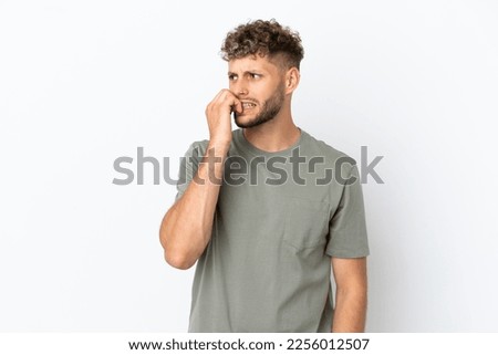 Young caucasian handsome man isolated on white background is a little bit nervous