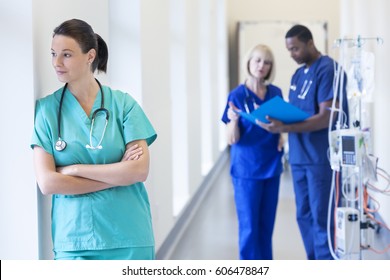 Young Caucasian Healthcare Female In Nursing Scrubs With Multi Ethnic Hospital Staff In Medical Facility