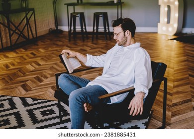 young caucasian hipster guy making research of useful information in literature book - Powered by Shutterstock