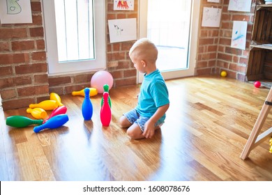 Young Caucasian Kid Playing Bowling At Kindergarten. Preschooler Boy Happy At Playroom With Toys