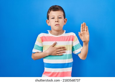 Young Caucasian Kid Standing Over Blue Background Swearing With Hand On Chest And Open Palm, Making A Loyalty Promise Oath 