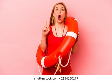 Young Caucasian Life Guard Woman Isolated On Pink Background Pointing Upside With Opened Mouth.