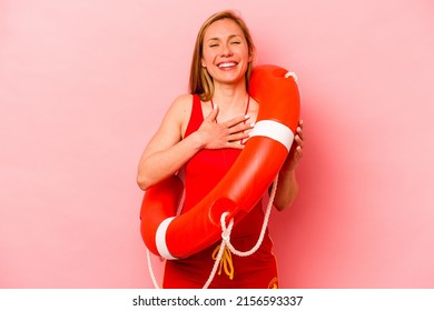 Young Caucasian Life Guard Woman Isolated On Pink Background Laughs Out Loudly Keeping Hand On Chest.