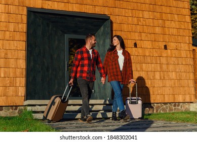 Young Caucasian Lovely Couple With Luggage Leaving House For Joint Vacation. Happy Family Concept.