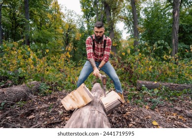 A young Caucasian lumberjack energetically chopping wood with an axe in the forest. - Powered by Shutterstock