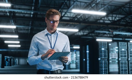 Young Caucasian Male Employee Uses Tablet Computer in System Control Monitoring Center at Night. Evening Office In the Background. Cyber Security and Network Protection Concept - Powered by Shutterstock