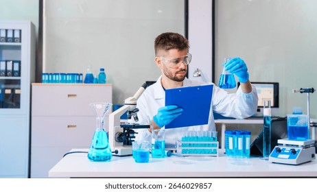 Young Caucasian male scientist works in laboratory, analyzing chemical samples with glassware and microscope. research tools, experiments, data interpretation, pharmaceutical development.