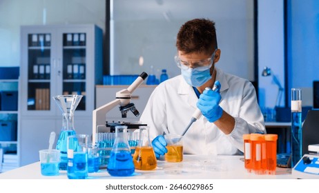 Young Caucasian male scientist works in laboratory, analyzing chemical samples with glassware and microscope. research tools, experiments, data interpretation, pharmaceutical development.