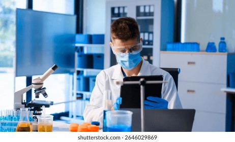 Young Caucasian male scientist works in laboratory, analyzing chemical samples with glassware and microscope. research tools, experiments, data interpretation, pharmaceutical development.