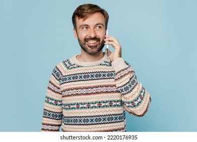 Young Caucasian Man 30s He Wear Sweater Talk Speak On Mobile Cell Phone Conducting Pleasant Conversation Isolated On Plain Pastel Light Blue Cyan Background Studio Portrait. People Lifestyle Concept