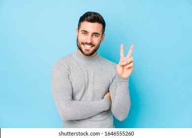 Young Caucasian Man Against A Blue Background Isolated Showing Number Two With Fingers.