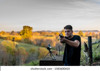 Young Caucasian Man Aiming Pistol At Target At Outdoor Firing Range Or Shooting Range In Kentucky