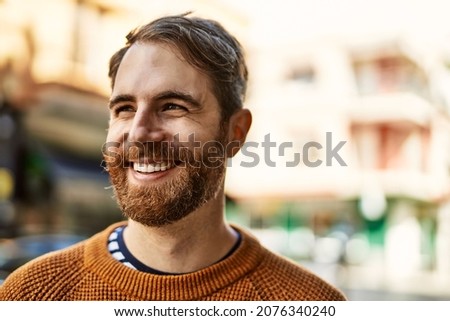 Young caucasian man with beard outdoors on a sunny day