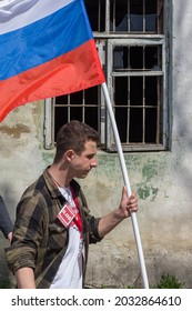 Young Caucasian Man Carrying Russian Tricolor Flag In Front Of Broken Window With Steel Bars At Political Meeteing Supporting Alexey Navalny, Tula, Russia, 05 05 2018