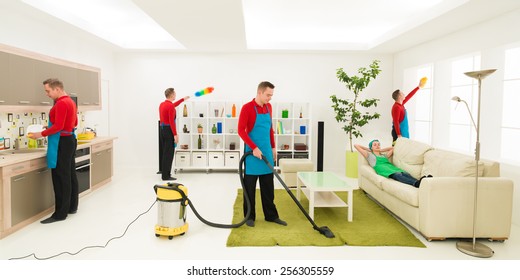 Young Caucasian Man Cleaning Home In Different Places At The Same Time While Wife Rests On Sofa