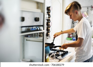Young caucasian man cooking in the kitchen
