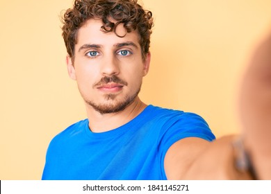 Young Caucasian Man With Curly Hair Wearing Casual Clothes Taking A Selfie Thinking Attitude And Sober Expression Looking Self Confident 