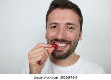 Young Caucasian Man Eating Red Gummy Candy 