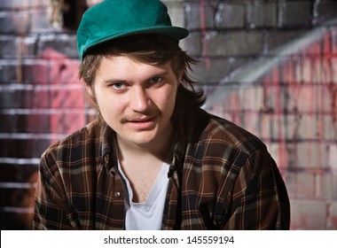 Young Caucasian Man In Flannel Shirt Sitting Outside