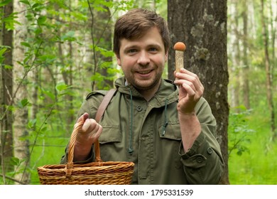 Young Caucasian Man Gathers Mushrooms Showing A Cep From Basket.