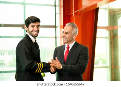 Young Caucasian Man Have Beard In Pilot Uniform Shaking Hands With Senior In Suit For Say Hello Together After Success Finishing Up A Meeting Collaboration,Two Business People Agreement,teamwork.