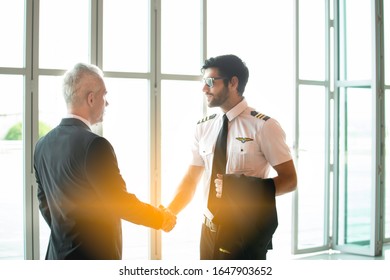 Young Caucasian Man Have Beard In Pilot Uniform Shaking Hands With Senior In Suit For Say Hello Together After Success Finishing Up A Meeting Collaboration,Two Business People Agreement,teamwork.