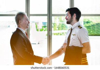 Young Caucasian Man Have Beard In Pilot Uniform Shaking Hands With Senior In Suit For Say Hello Together After Success Finishing Up A Meeting Collaboration,Two Business People Agreement,teamwork.