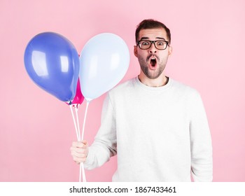 Young Caucasian Man Holding Balloons With Surprised Expression And Celebrating A Brithday Isolated In A Pink Background