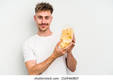 Young caucasian man holding crisps isolated on white background