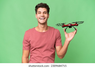 Young caucasian man holding a drone over isolated background with surprise and shocked facial expression