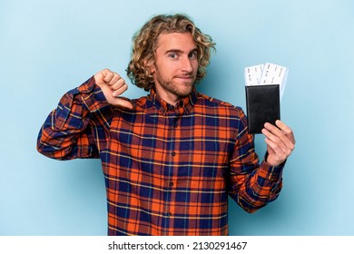 Young Caucasian Man Holding A Passport Isolated On Blue Background Feels Proud And Self Confident, Example To Follow.