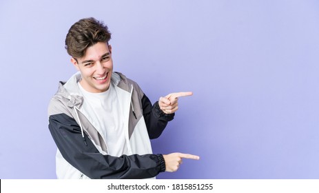 Young caucasian man isolated on purple background pointing with forefingers to a copy space, expressing excitement and desire. - Shutterstock ID 1815851255