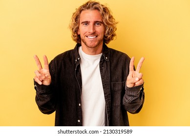 Young caucasian man isolated on yellow background showing victory sign and smiling broadly. - Powered by Shutterstock