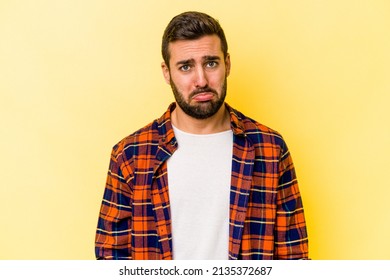 Young Caucasian Man Isolated On Yellow Background Sad, Serious Face, Feeling Miserable And Displeased.