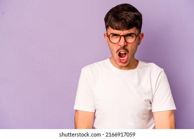 Young Caucasian Man Isolated On Purple Background Shouting Very Angry, Rage Concept, Frustrated.