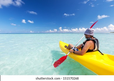 Young caucasian man kayaking in sea at Maldives 