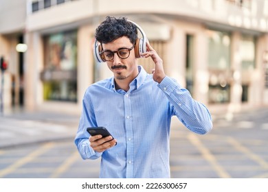 Young caucasian man listening to music at street - Powered by Shutterstock