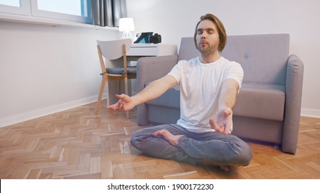 Young Caucasian Man Meditating In His Appartment. Mental Clarity And Wellbeing Concept. High Quality Photo