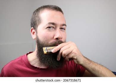 Young caucasian man playing harmonica 