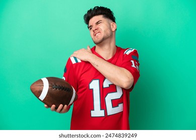 Young caucasian man playing rugby isolated on green background suffering from pain in shoulder for having made an effort - Powered by Shutterstock