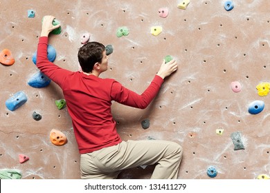 Young Caucasian Man Rock Climbing Indoors