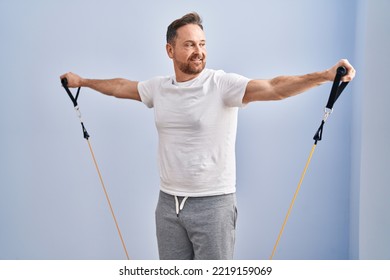 Young Caucasian Man Smiling Confident Using Elastic Band Training At Sport Center
