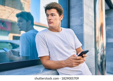 Young caucasian man smiling happy using smartphone at the city. - Shutterstock ID 1829005709