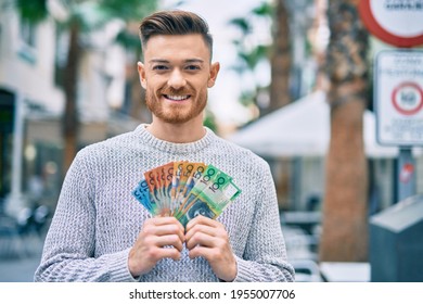 Young Caucasian Man Smiling Happy Holding Australian Dollars At The City.