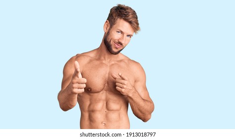 Young caucasian man standing shirtless pointing fingers to camera with happy and funny face. good energy and vibes.  - Powered by Shutterstock