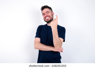 Young Caucasian Man Wearing Black T-shirt Over White Background Beckoning Come Here Gesture With Hand Inviting Welcoming Happy And Smiling