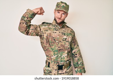 Young Caucasian Man Wearing Camouflage Army Uniform Strong Person Showing Arm Muscle, Confident And Proud Of Power 