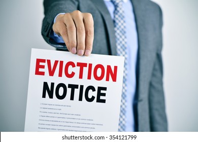 a young caucasian man wearing a gray suit shows a document with the text eviction notice - Shutterstock ID 354121799