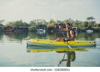 Young Caucasian Man Wearing Life Vest Kayaking.