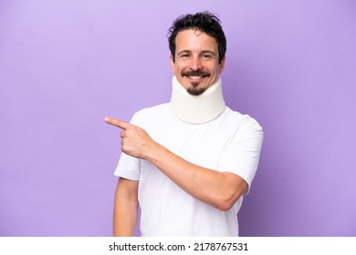 Young caucasian man wearing neck brace isolated on purple background pointing to the side to present a product